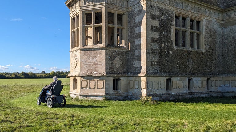 A visitor riding the personal mobility scooter around the garden lodge.